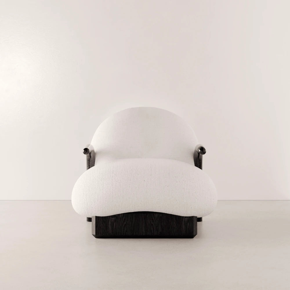 Front view of the Winter Armchair by Antony Gasnier with a rounded white fabric seat, enveloping backrest and dark oak base