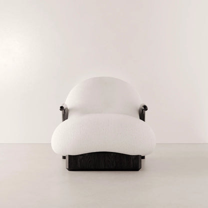 Front view of the Winter Armchair by Antony Gasnier with a rounded white fabric seat, enveloping backrest and dark oak base