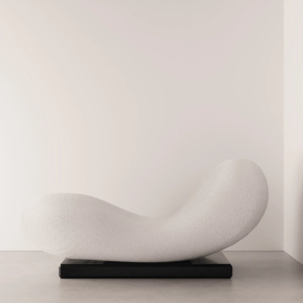Side view of the Winter Daybed by Antony Gasnier, highlighting its curved upholstered form and dark solid oak base