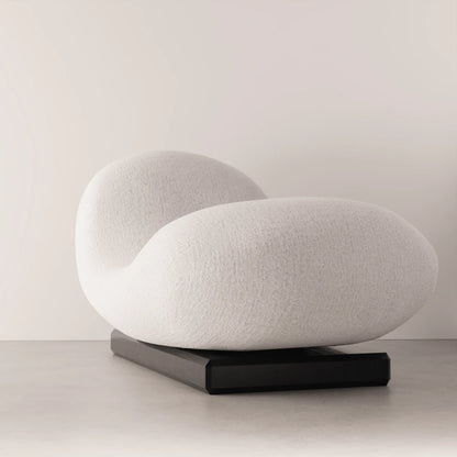 Three-quarter view of the Winter Daybed by Antony Gasnier, showing its sculpted white upholstery and dark oak base