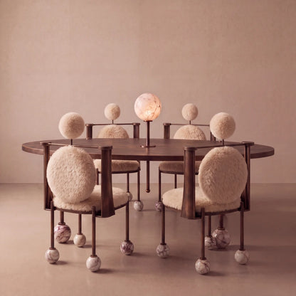 Ballet dining chairs by Diamant Versatile arranged around the matching table, with cream fur upholstery, bronze-toned frames and marble feet.