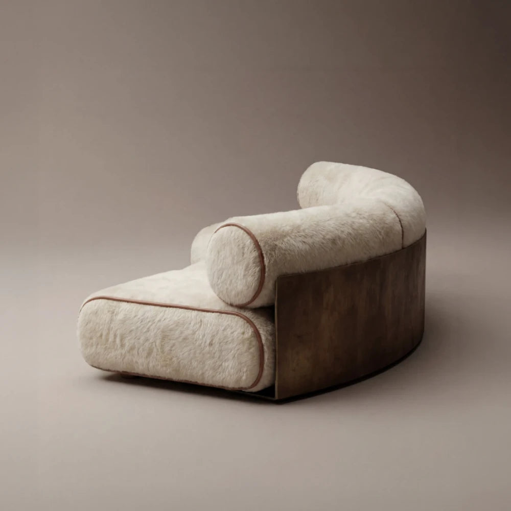 Three-quarter view of the Étreinte sofa by Diamant Versatile, featuring cream textured upholstery, brown piping and a curved metal shell.