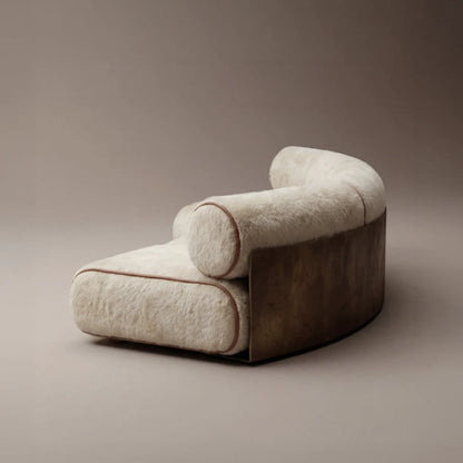 Three-quarter view of the Étreinte sofa by Diamant Versatile, featuring cream textured upholstery, brown piping and a curved metal shell.