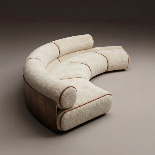 High-angle view of the curved Étreinte sofa, with modular cream seats, cylindrical backrests and contrasting brown piping.