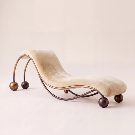 Three-quarter view of the Pendule chaise lounge by Diamant Versatile, with ivory mohair upholstery and a sculptural metal frame with spherical feet.