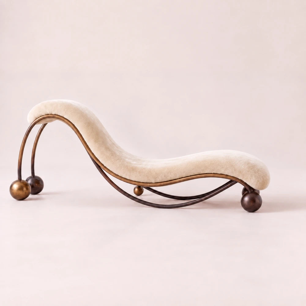 Side view of the Pendule chaise lounge by Diamant Versatile, highlighting its flowing ivory mohair seat and curved metal structure.