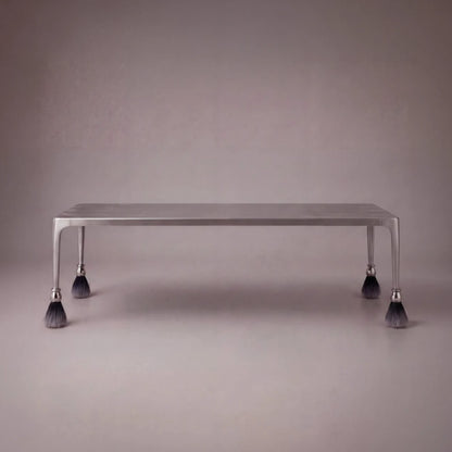Product view of the rectangular Pompon dining table by Diamant Versatile, featuring a brushed metal frame and tassel-tipped legs.