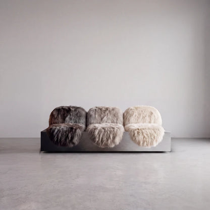 Isolated front view of the Sans Poids Gradient sofa by Diamant Versatile, featuring three long-haired fur seats on a brushed metal base.