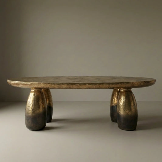 Front view of the Solum dining table by Diamant Versatile, with an elongated bronze top and rounded sculptural legs.