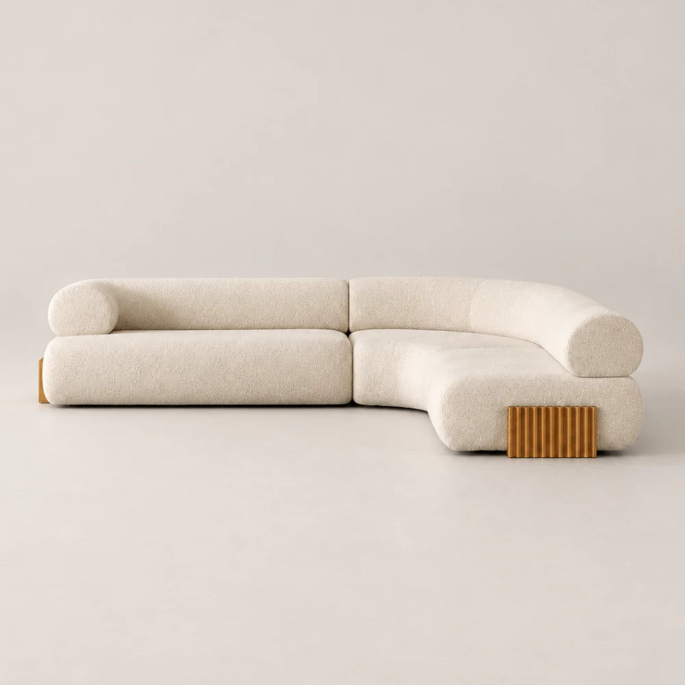 Front view of the Carmel Modular Sofa by Dooq Details, featuring cream textured upholstery, rounded backrests, a right-hand chaise and ribbed gold-toned base accents.
