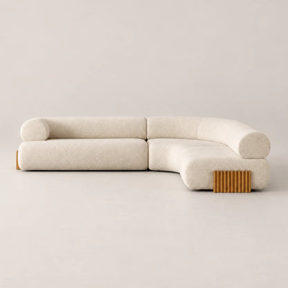Front view of the Carmel Modular Sofa by Dooq Details, featuring cream textured upholstery, rounded backrests, a right-hand chaise and ribbed gold-toned base accents.