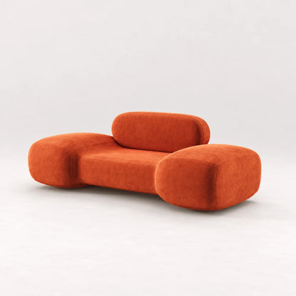 Front view of the Infinity Armchair 02 by Eva Szumilas in orange upholstery, with oversized rounded arms, a low seat and pill-shaped backrest.