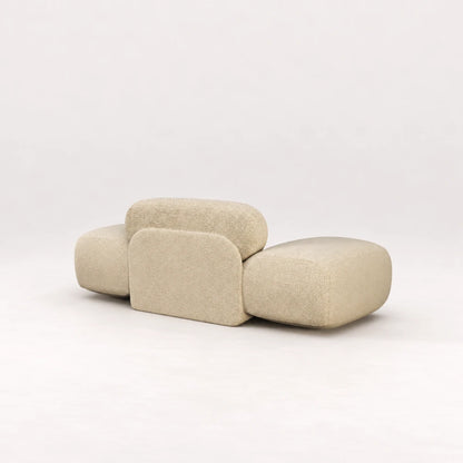 Rear view of the Infinity Armchair 02 by Eva Szumilas in textured ivory upholstery, highlighting its central padded support panel and oversized rounded arms.