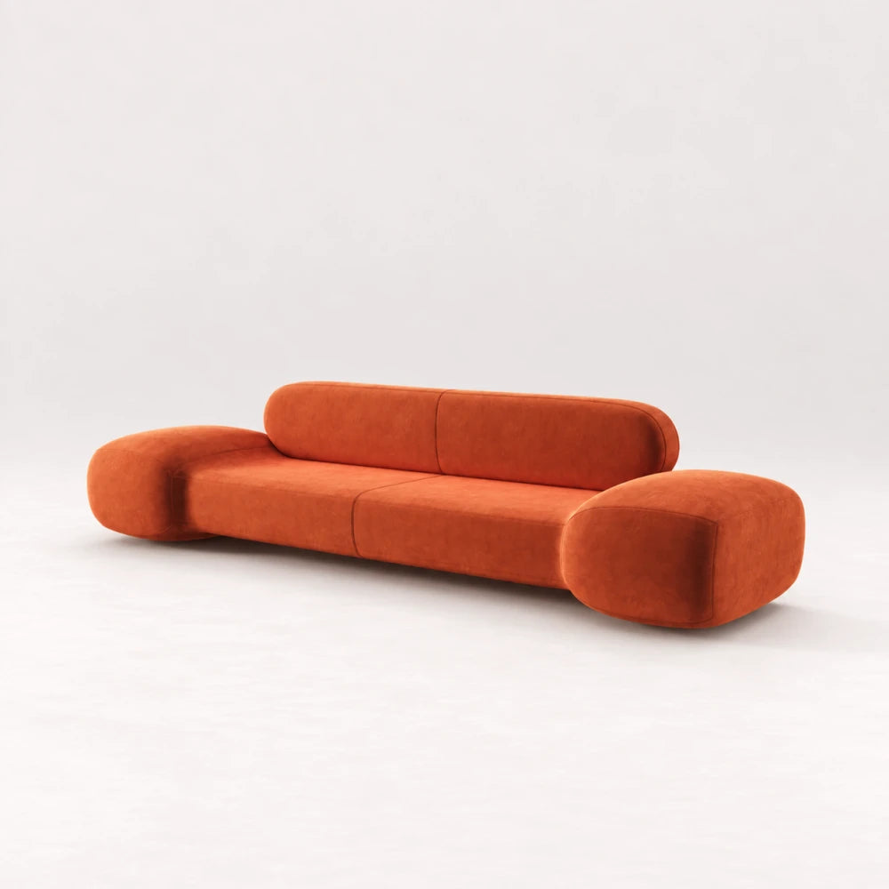 Front view of the Infinity Sofa 02 by Eva Szumilas in orange upholstery, with oversized rounded arms, a low seat and an elongated padded backrest.