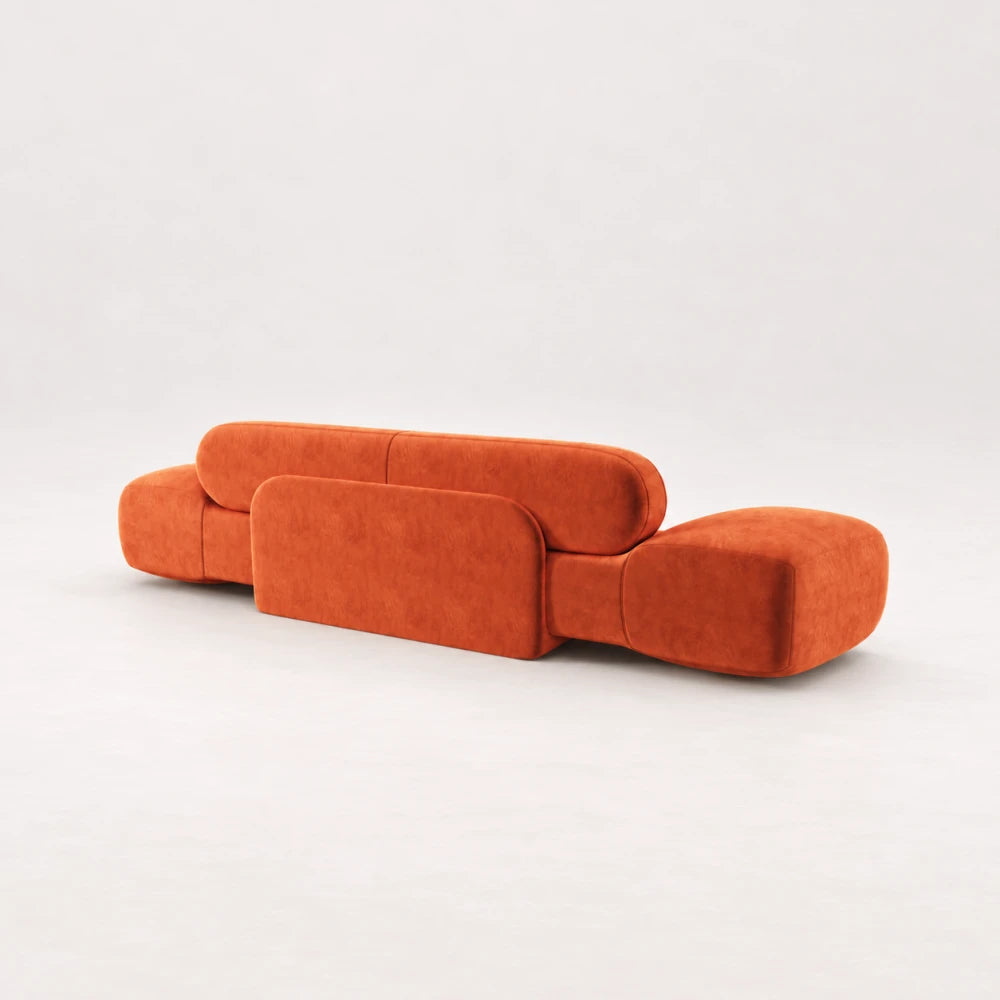 Rear view of the Infinity Sofa 02 by Eva Szumilas in orange upholstery, showing its central rounded support panel and broad curved ends.