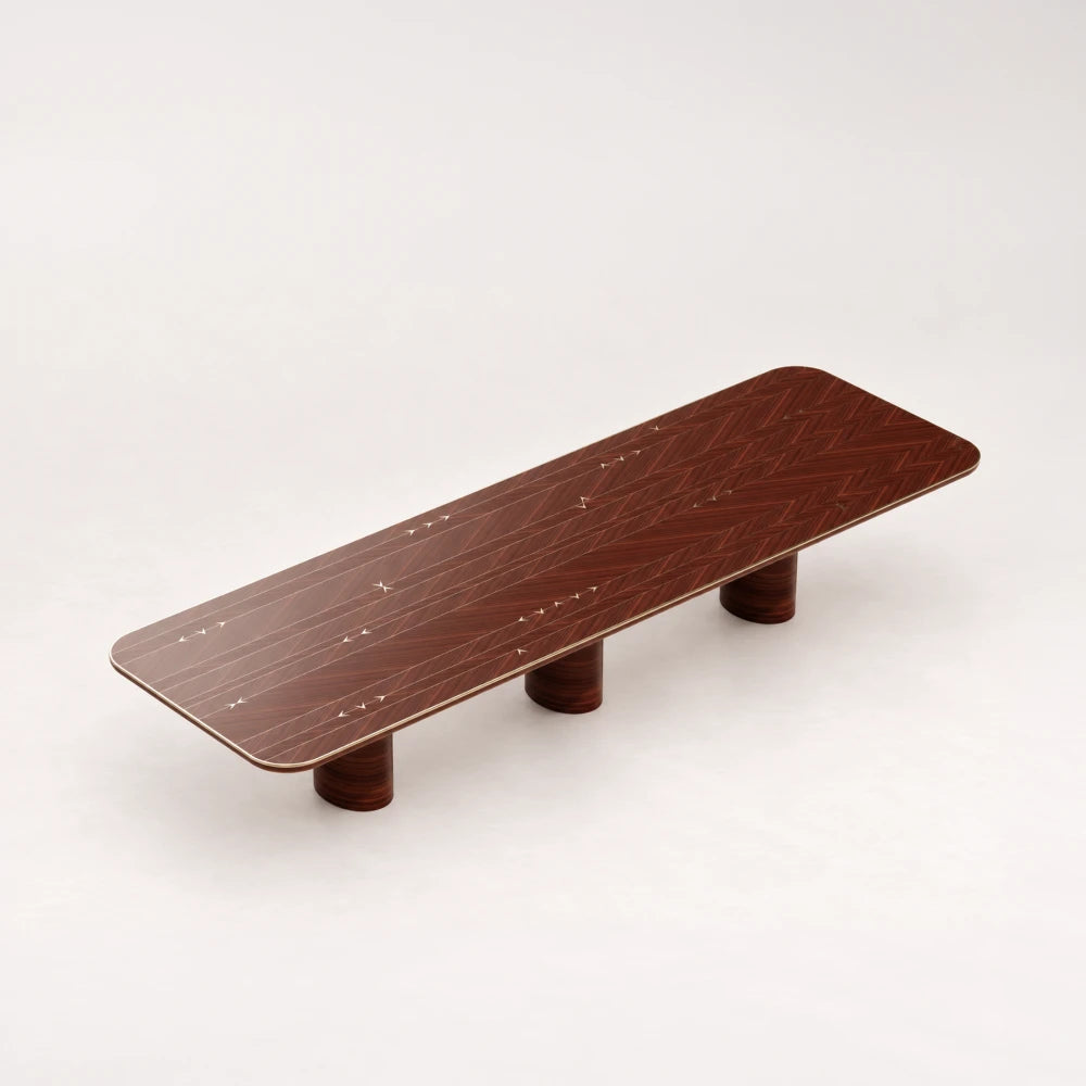 DT01 Dining Table from the X Collection by Eva Szumilas in reddish wood, with patterned grain, pale arrow inlays and three cylindrical supports.