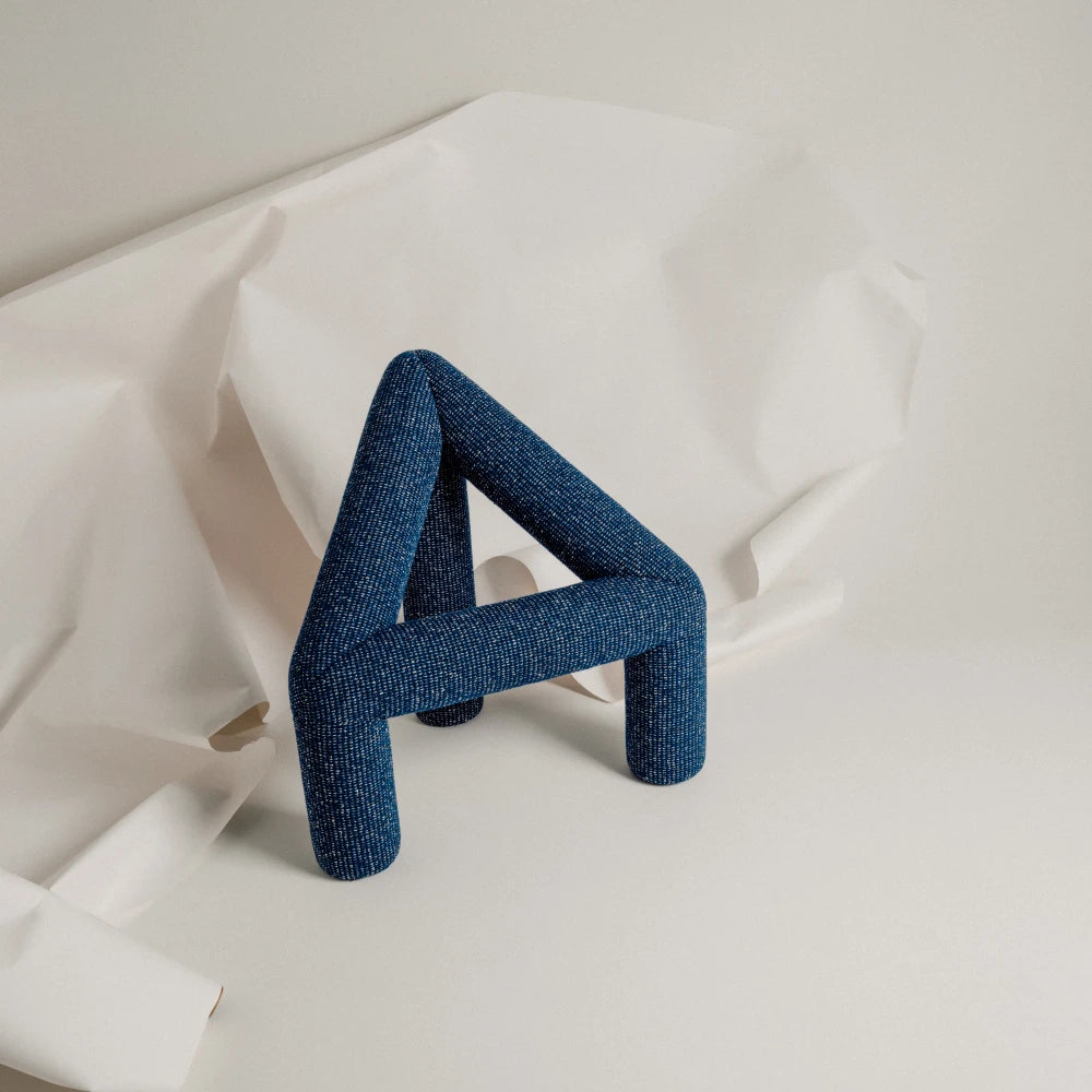 Elevated three-quarter view of the blue A Chair by Garnier Pingree, showing its triangular open frame, rounded legs and textured upholstery.