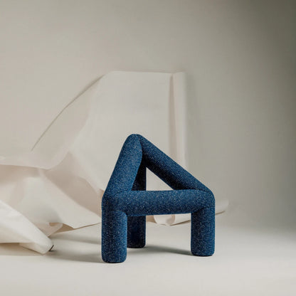Closer view of the blue A Chair by Garnier Pingree, highlighting its woven upholstery, rounded joints and three substantial legs.