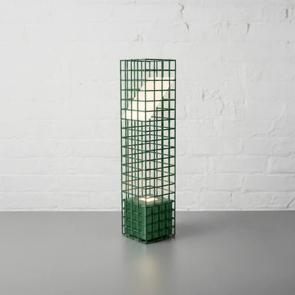 Three-quarter view of the green Ami Desk Lamp by Garnier Pingree, showing its open metal grid, square base and angled luminous panel.