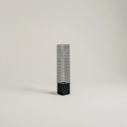 Full studio view of the unlit black Ami Table Lamp by Garnier Pingree, with a slender metal grid column and solid square base.
