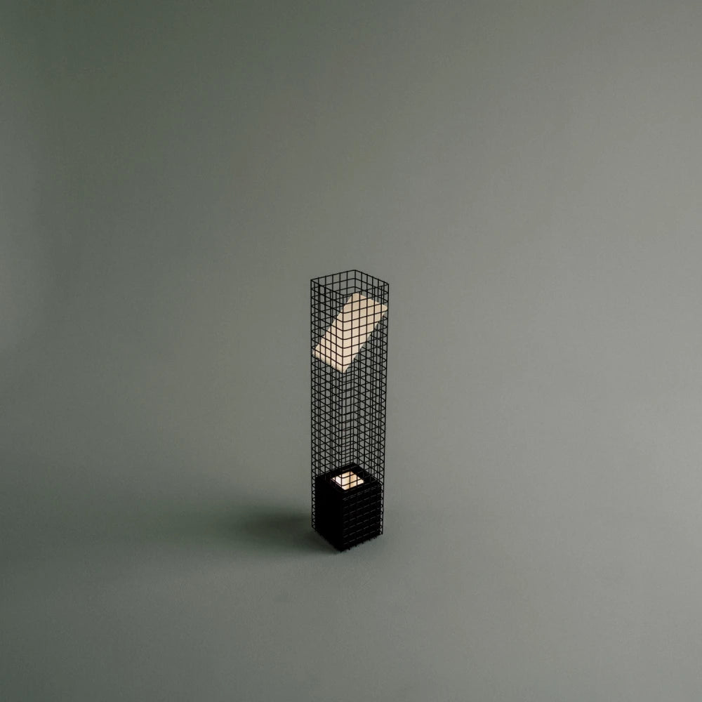 Elevated three-quarter view of the illuminated Ami Table Lamp by Garnier Pingree, showing its glowing angled panel and small light above the base.