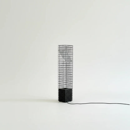 Unlit black Ami Table Lamp by Garnier Pingree against a pale background, showing its grid frame, angled panel and trailing black cable.
