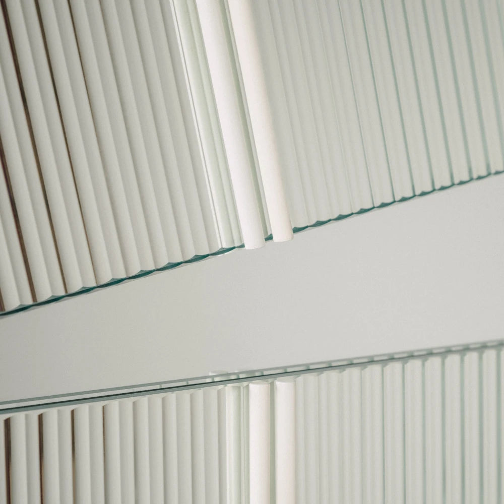Close-up of the large Claude Mirror by Garnier Pingree, highlighting ribbed glass edges, white rods and the mirrored strip between the panels.
