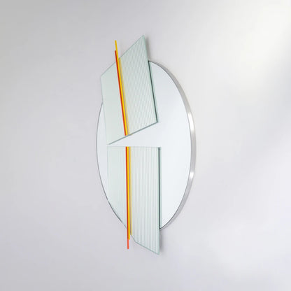 Angled view of the large Claude Mirror by Garnier Pingree, with red-orange and yellow rods across two ribbed glass panels and a circular mirror.