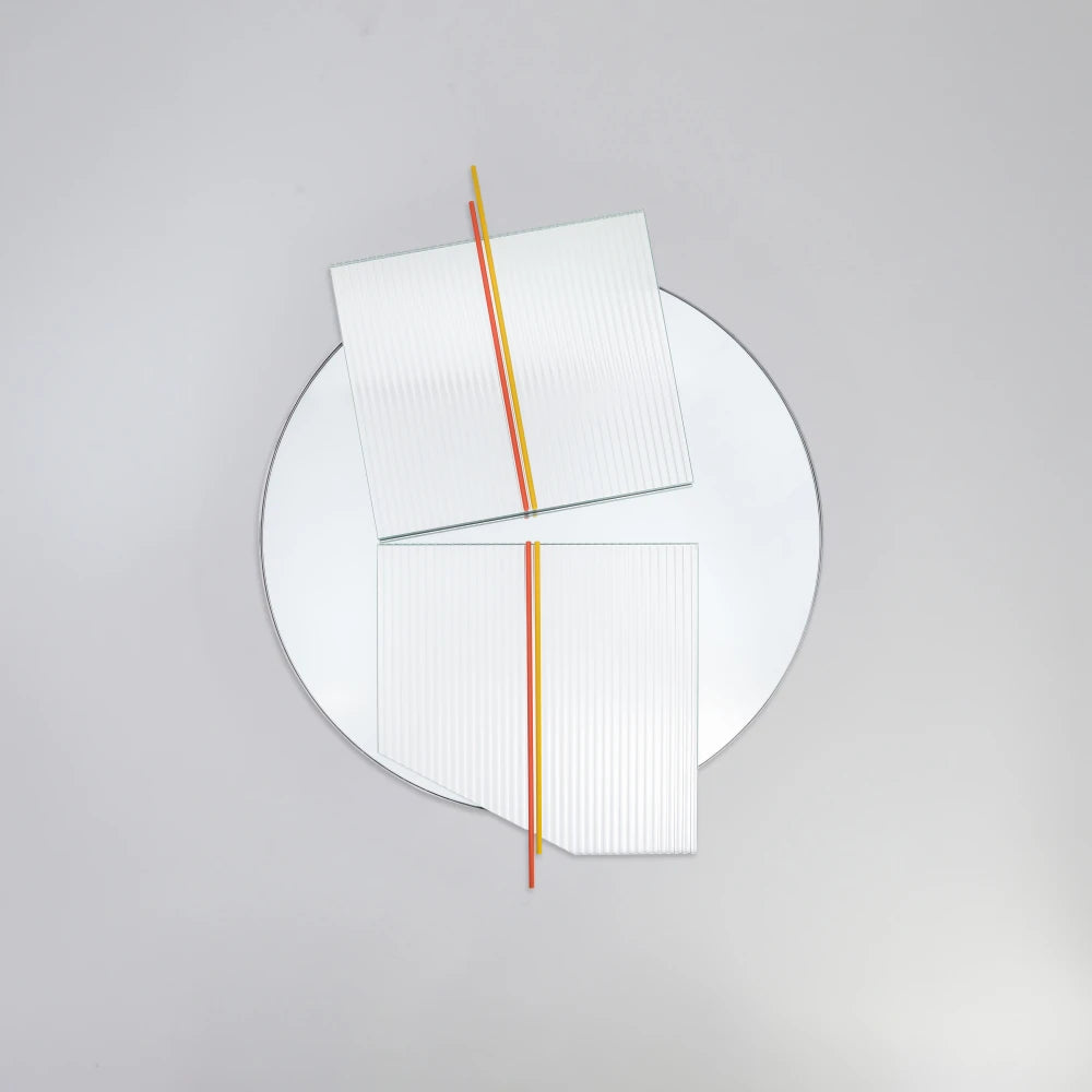 Front view of the large Claude Mirror by Garnier Pingree, showing red-orange and yellow rods, offset ribbed glass panels and a circular reflective surface.