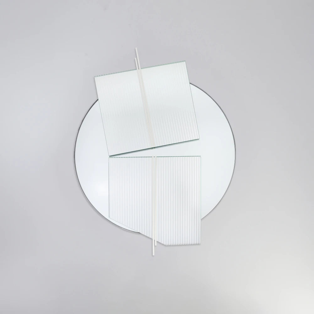 Front view of the large Claude Mirror by Garnier Pingree, with white rods crossing two offset ribbed glass panels over a circular mirror.