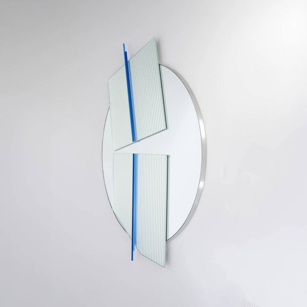 Side view of the large Claude Mirror by Garnier Pingree, with blue rods crossing two projecting ribbed glass panels over a circular mirror.