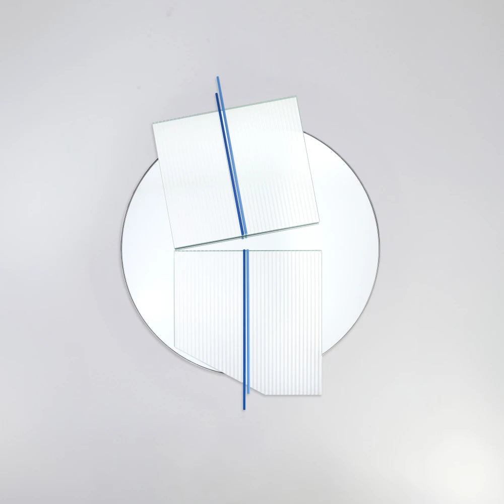 Front view of the large Claude Mirror by Garnier Pingree, featuring blue rods and two offset ribbed glass panels extending beyond its circular outline.