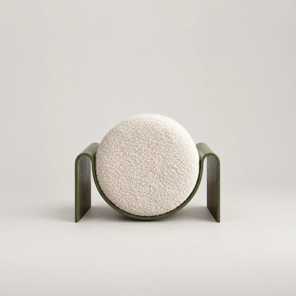 Front view of the Monitor Stool by Garnier Pingree, featuring a circular cream bouclé cushion cradled in a green frame with broad side supports.