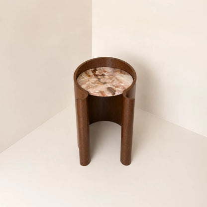 Elevated front view of the Volute Side Table by Garnier Pingree, revealing its multicoloured stone top and open curved wooden base.