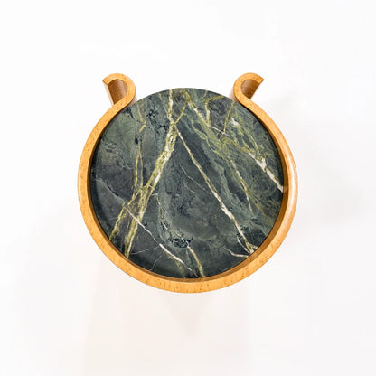 Overhead view of the Volute Side Table by Garnier Pingree, highlighting its circular green stone top, pale veining and curled maple edges.