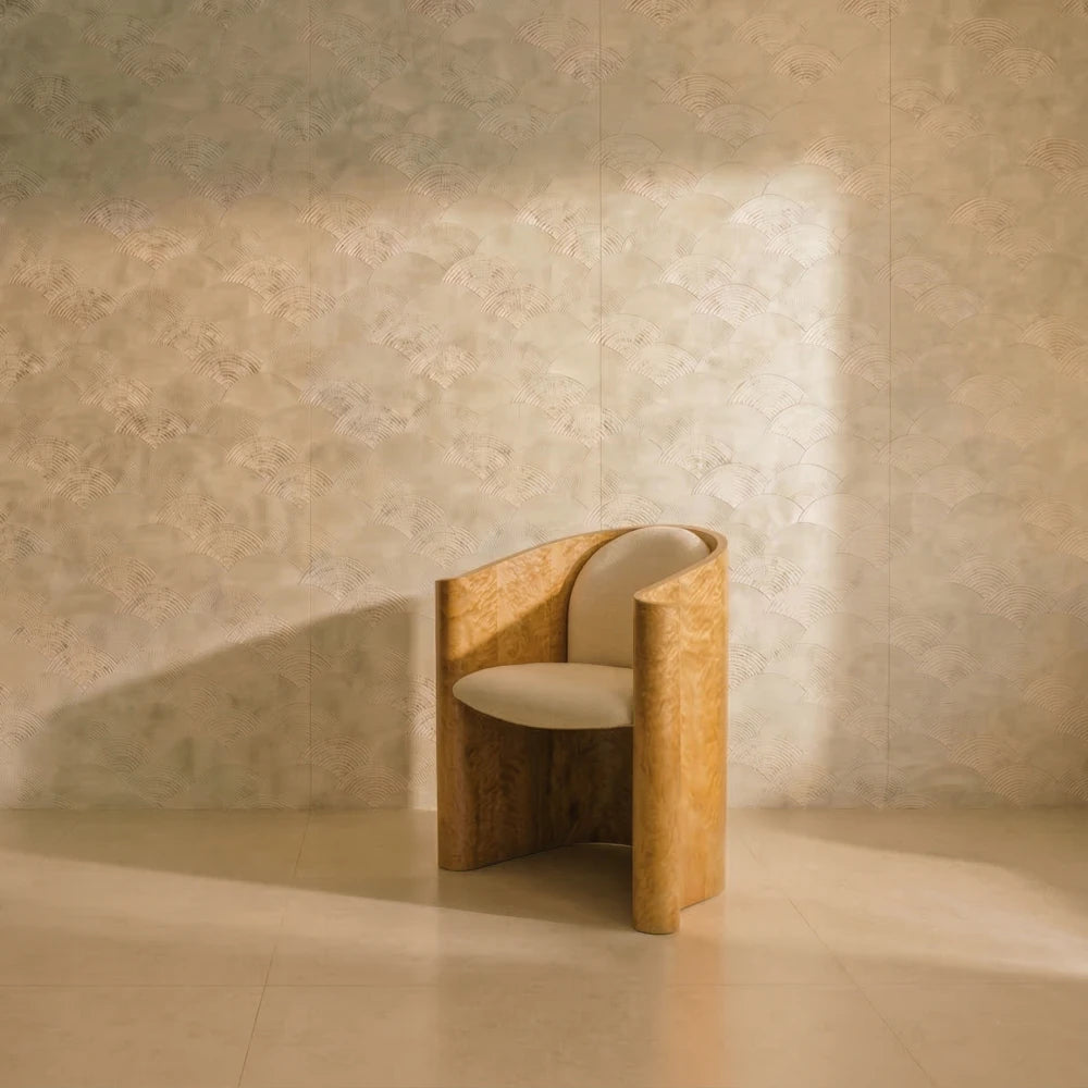 Volute Chair by Garnier Pingree in a sunlit beige interior, with golden figured wood surrounding cream seat and back cushions.