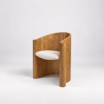 Three-quarter view of the Volute Chair by Garnier Pingree, showing its exposed figured wood back, cream seat and scrolling front edges.