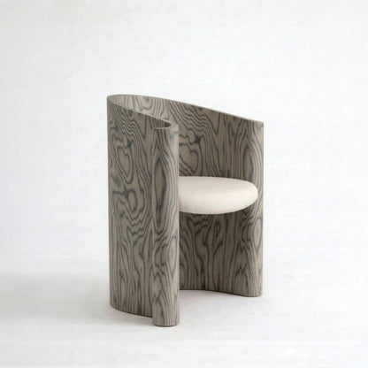 Volute Chair by Garnier Pingree in the Sottsass finish, with dark wavy grain across a grey wooden shell and a cream seat.