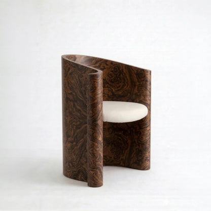 Volute Chair by Garnier Pingree in California Burl, with dark swirling wood grain, curved sides and a cream upholstered seat.