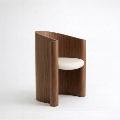 Walnut Volute Chair by Garnier Pingree, featuring a continuous curved shell, vertical wood grain and a cream upholstered seat.