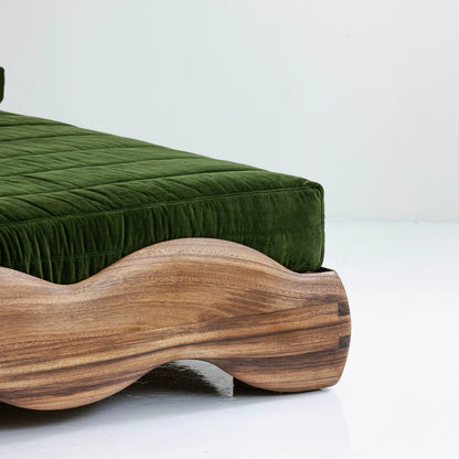 Close-up of the sculpted parota wood frame and green upholstery of Lola Bed
