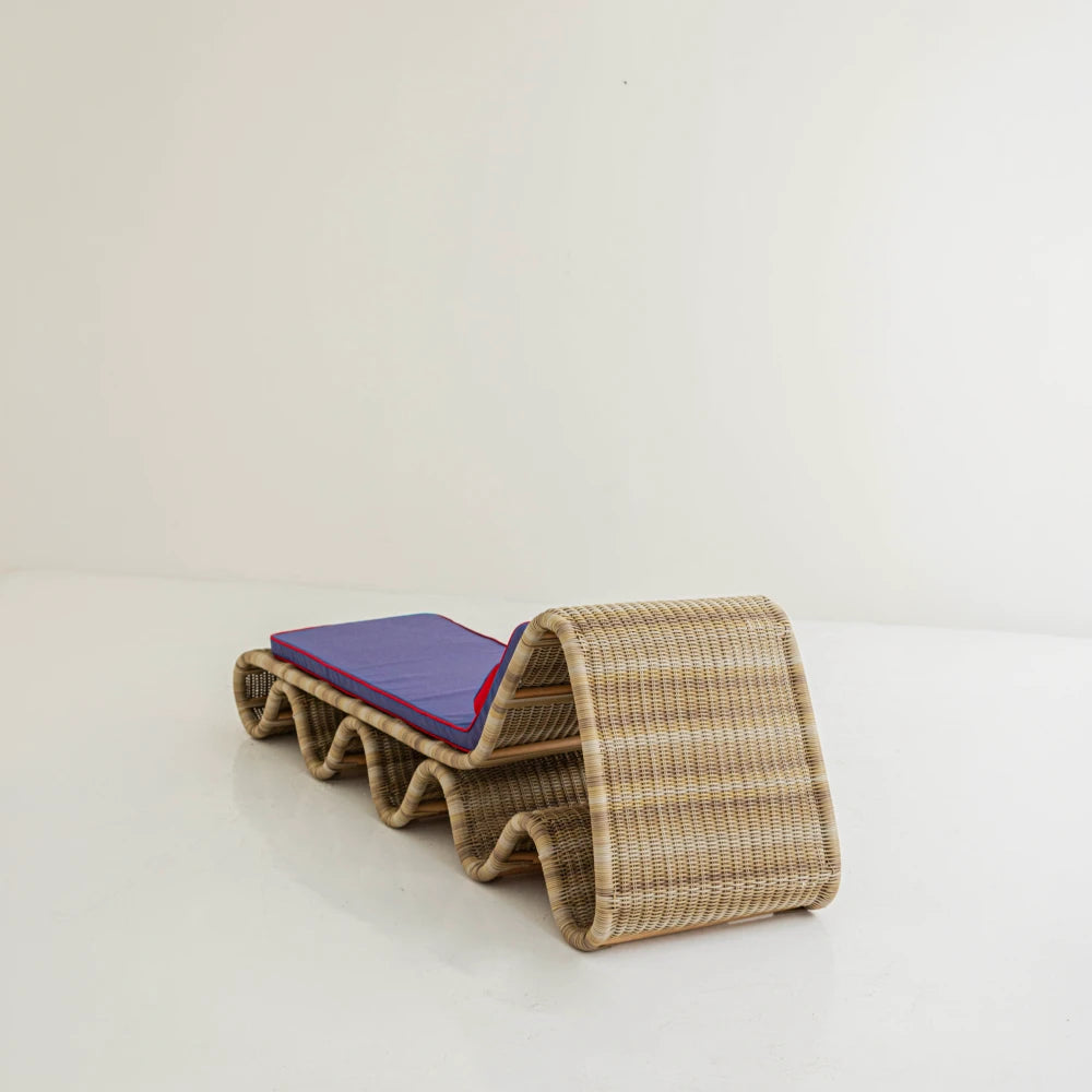 Rear three-quarter view of Lola Chaise Lounge, highlighting the curved woven rattan backrest