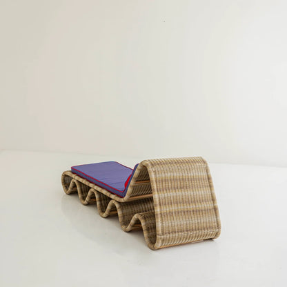 Rear three-quarter view of Lola Chaise Lounge, highlighting the curved woven rattan backrest