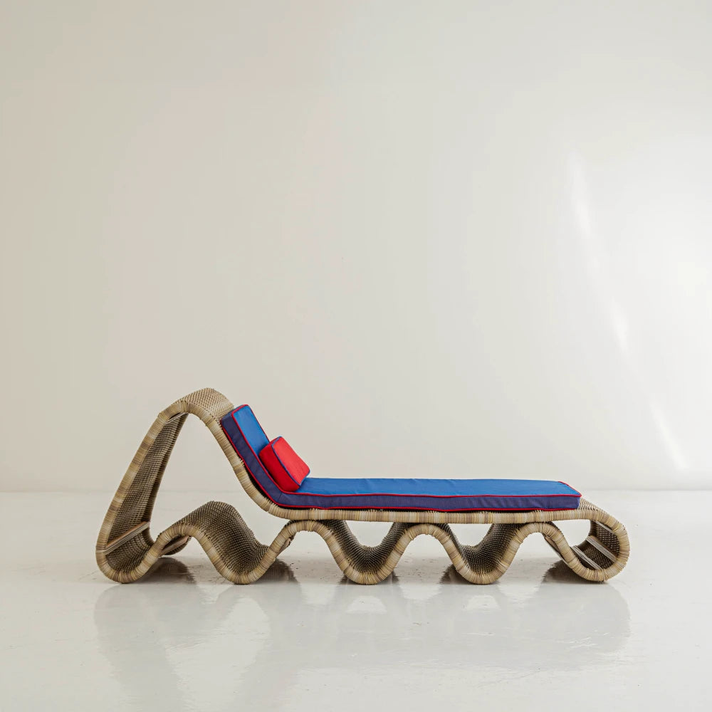 Side view of Lola Chaise Lounge by Joyful Objects, showing its wave-shaped woven rattan structure