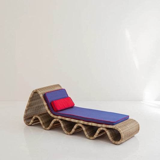 Lola Chaise Lounge in woven synthetic rattan with blue and red outdoor upholstery by Joyful Objects, three-quarter view