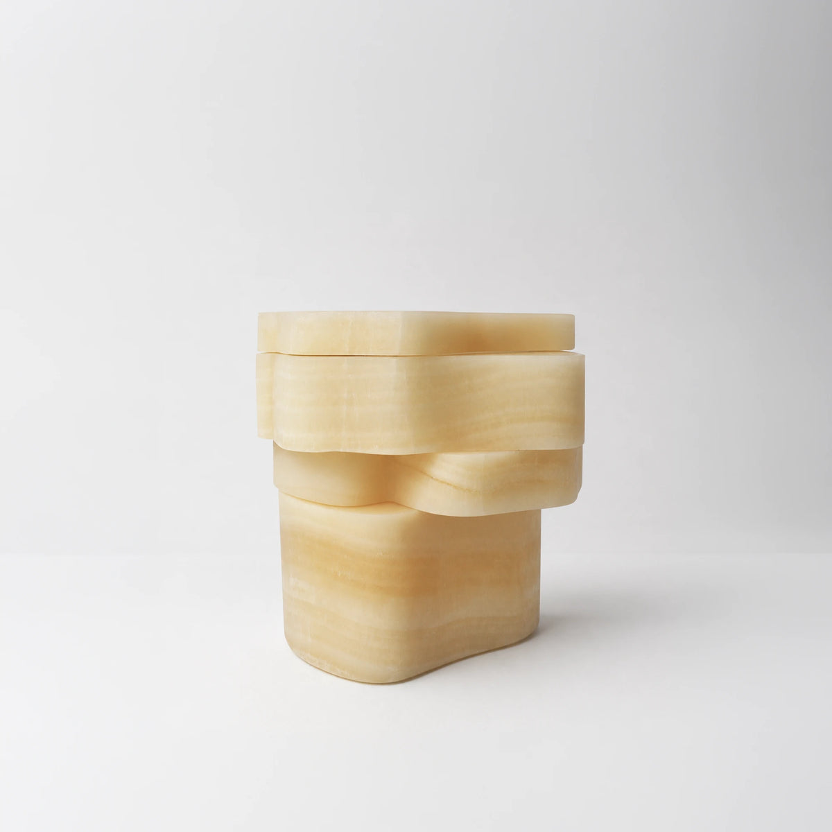 White Moth Nightstand in translucent white onyx by Panorammma, closed in a front three-quarter view