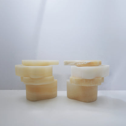 Two open White Moth Nightstands by Panorammma with their rotating onyx compartments arranged differently
