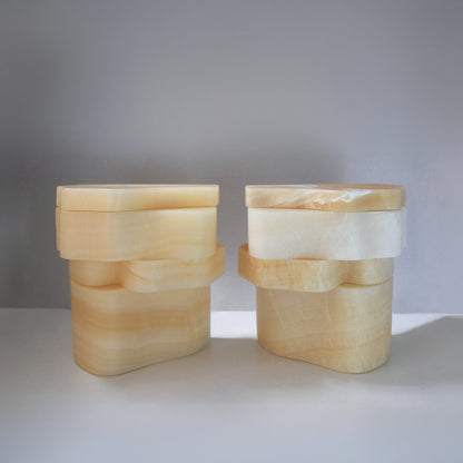 Two closed White Moth Nightstands by Panorammma showing the natural variations of translucent white onyx