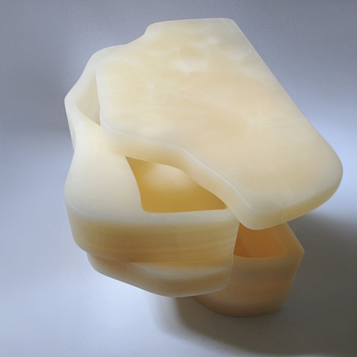Close overhead view of the White Moth Nightstand opened to reveal its carved onyx storage compartments