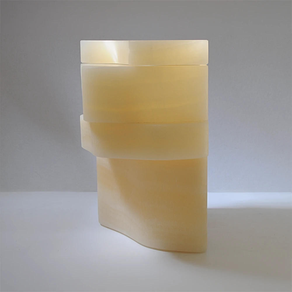 Rear three-quarter view of the closed White Moth Nightstand showing its asymmetrical onyx silhouette